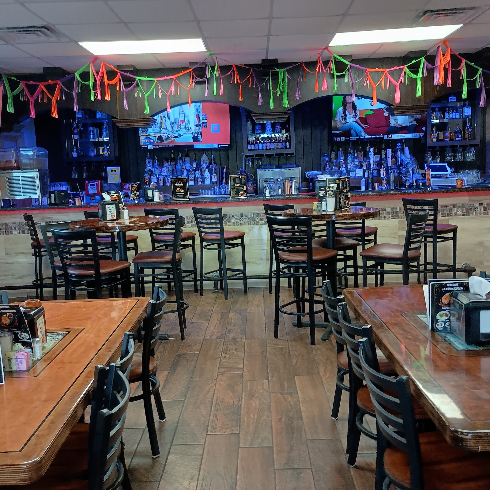 Festive bar area with string decorations and sports on TV